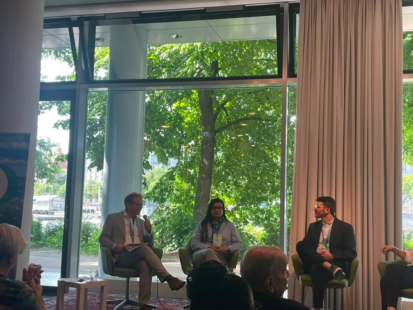 Amazon Week Berlin panel: speakers seated in front of large windows looking out onto greenery