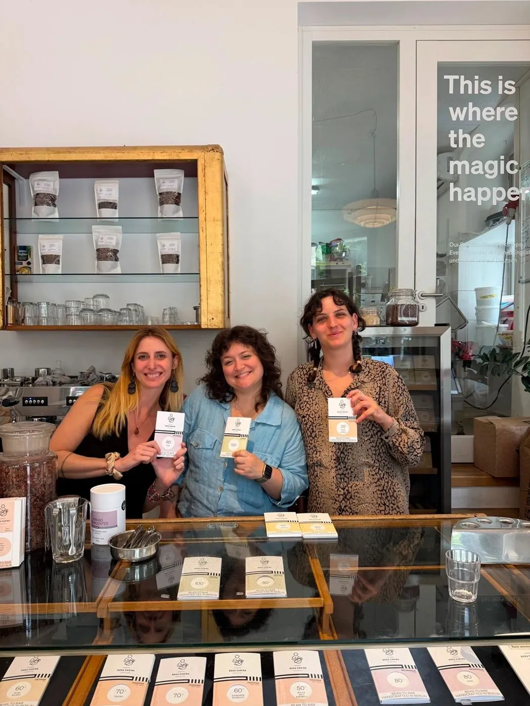 Three women tasting chocolate at a shop counter