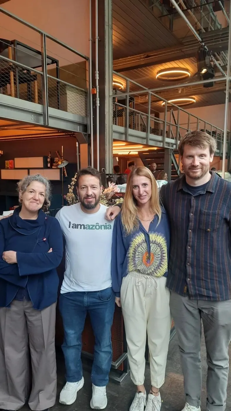 Vier Personen stehen nebeneinander im Betahaus, einer trägt ein T-Shirt mit der Aufschrift „Amazônia“