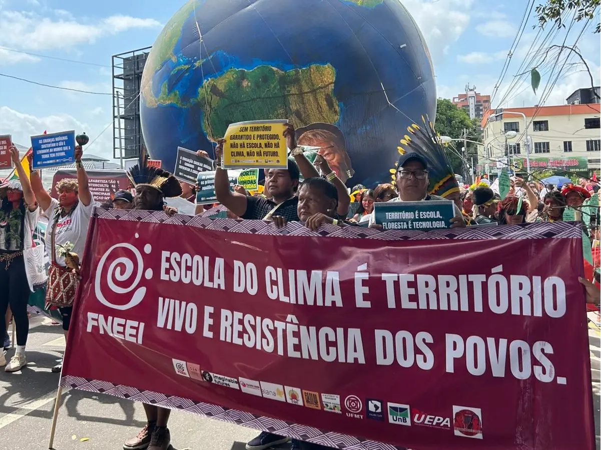 Demonstrationszug während der COP30 in Belém mit Transparent „Escola do clima é território vivo e resistência dos povos“